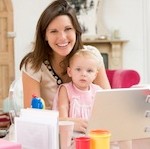 Mother and baby in home office with laptop