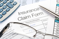 Handwritten Insurance Claim Form with pen and calculator